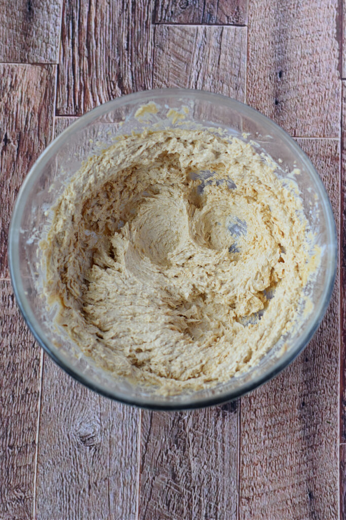 Mixed butter and sugar in a glass bowl.