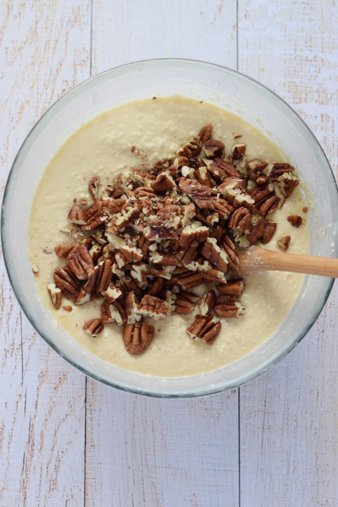 Adding chopped pecans to cookie dough.