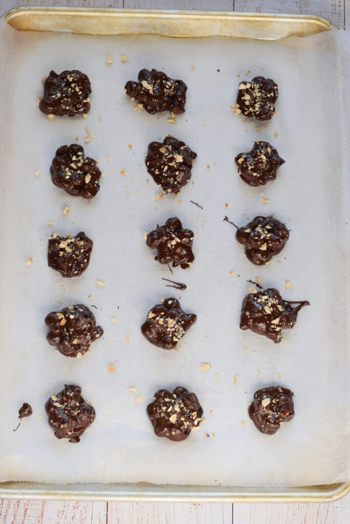 Chocolate hazelnut clusters on a baking tray.