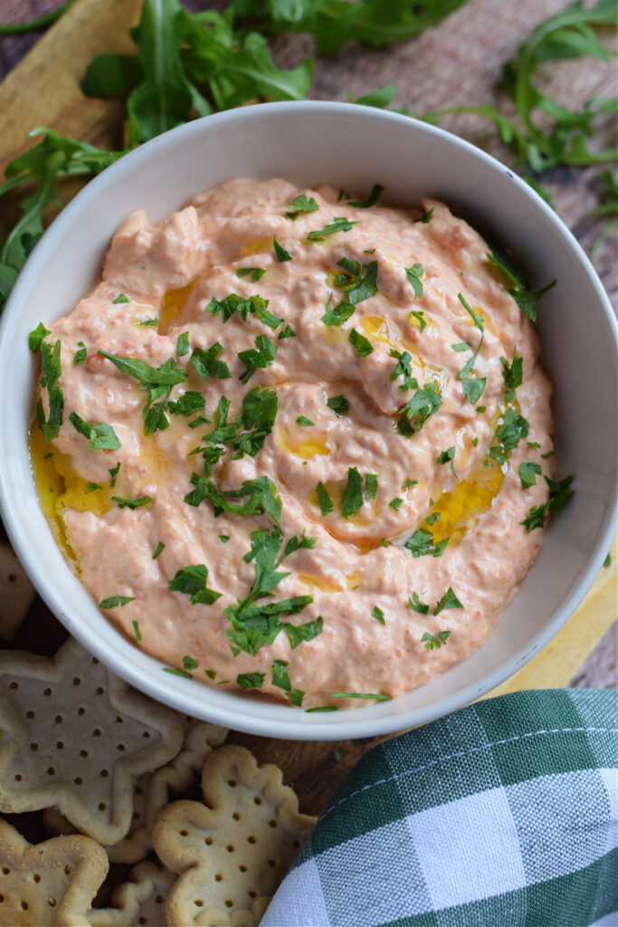 Close up of roasted bell pepper dip in a white bowl.