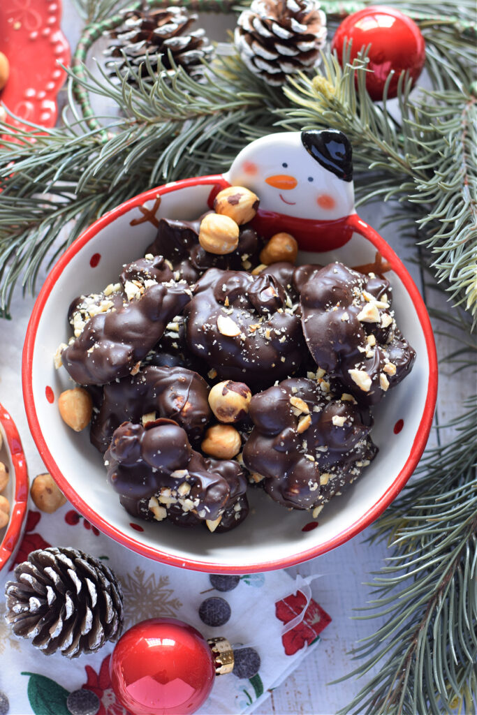 Chocolate hazelnut clusters in a white christmas bowl.