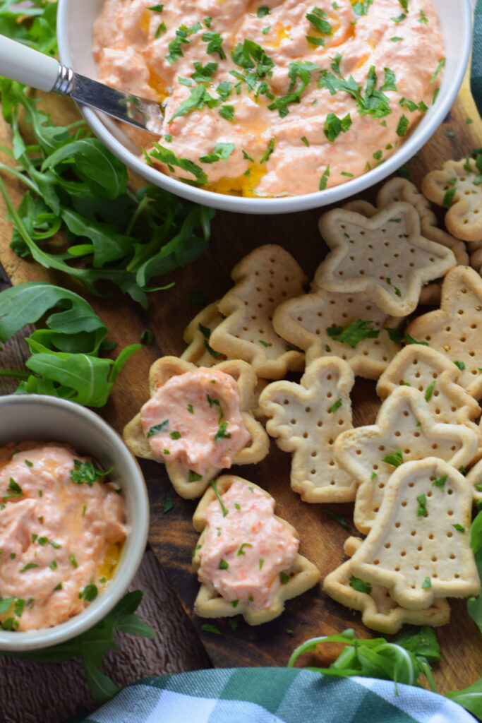 Roasted bell pepper dip with crackers on a tray.