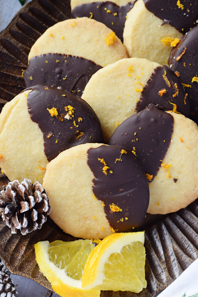 Orange chocolate shortbread cookies on a wooden plate.