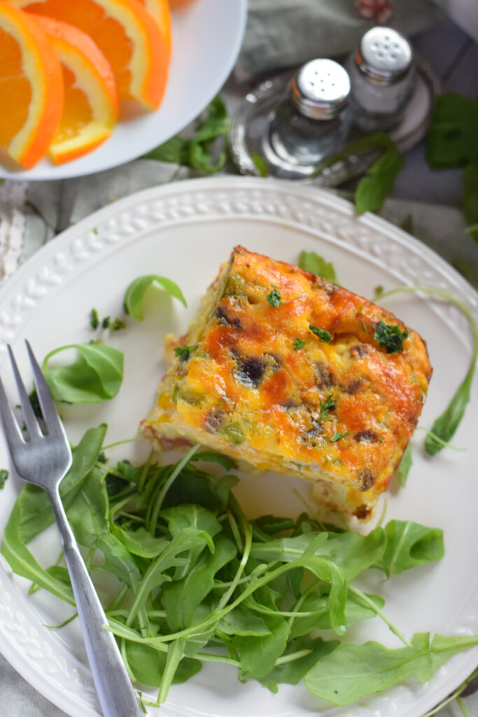 Bacon and egg breakfast casserole on a white plate.