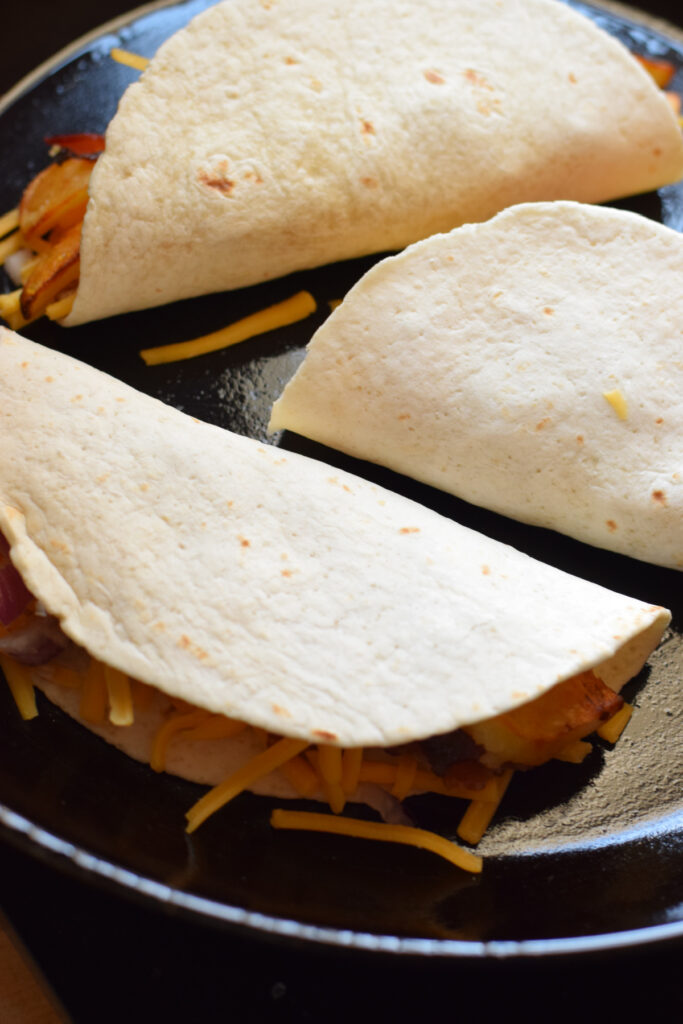 Cooking tacos in a skillet.