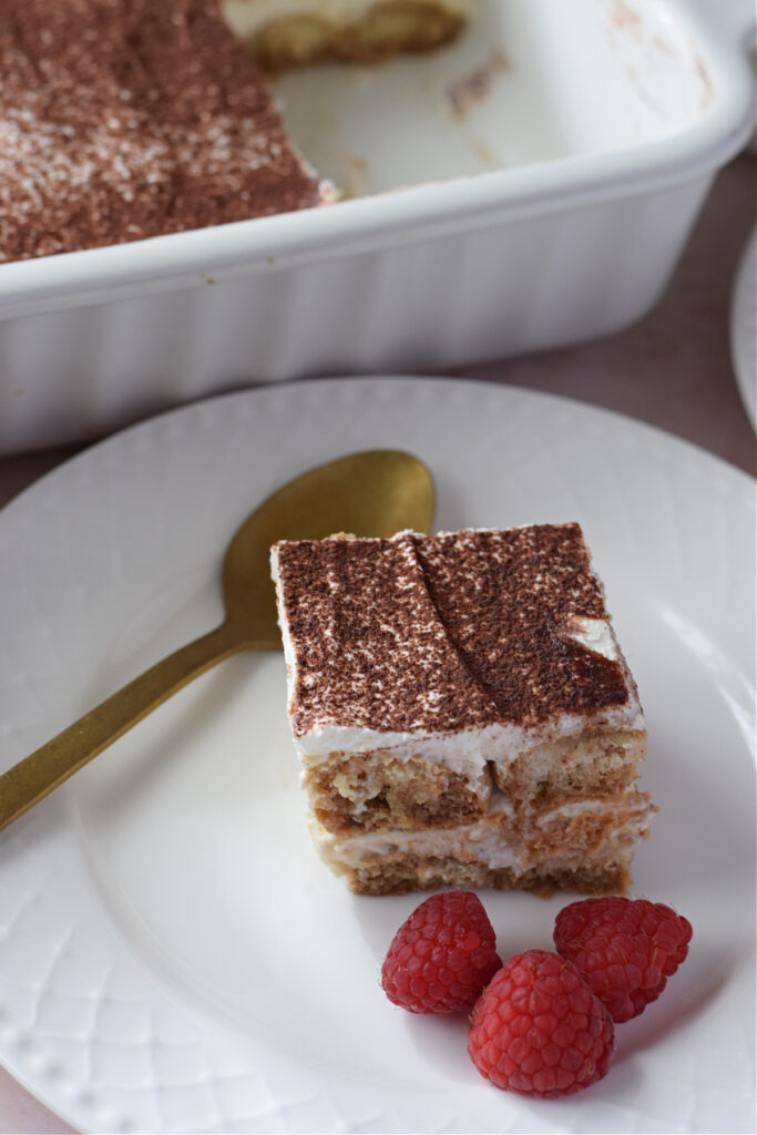 A slice of tiramisu on a white plate.