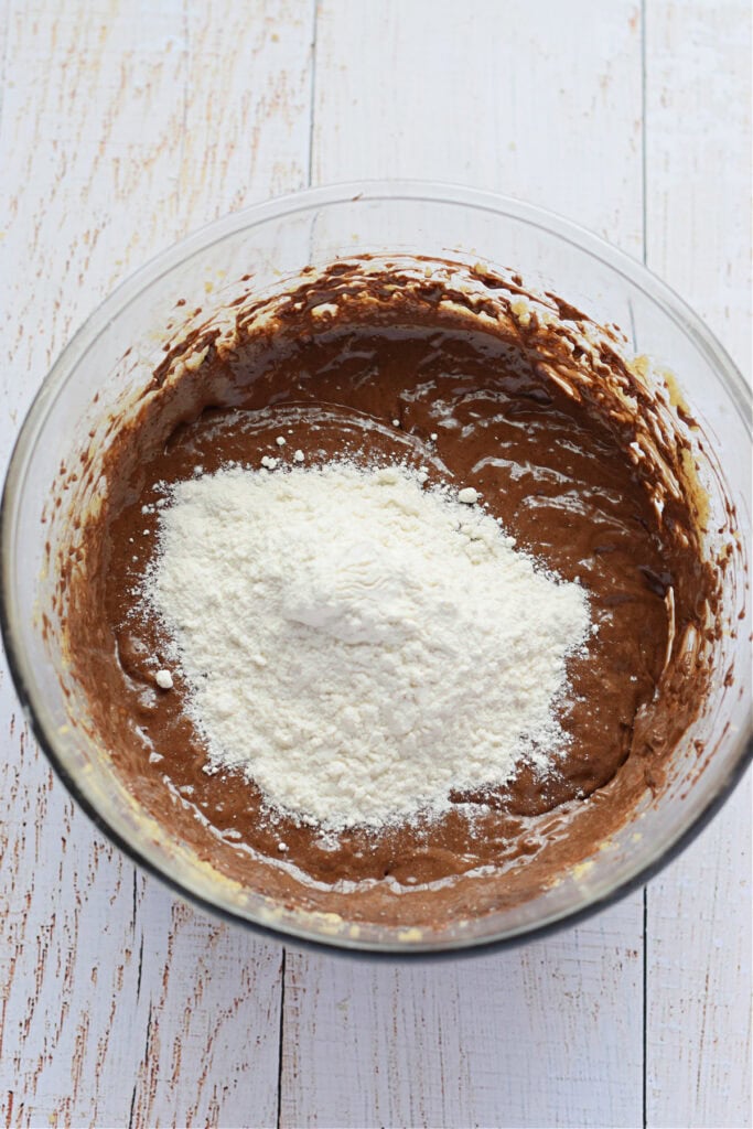 Adding flour to muffin batter.