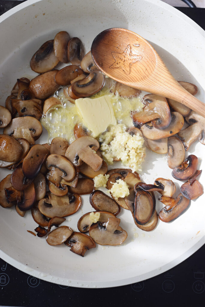Cooking mushrooms with butter and garlic.