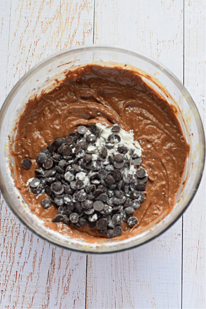 Folding in chocolate chips to muffin batter.