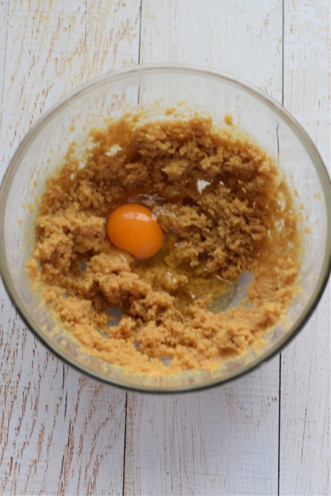 Adding eggs to muffin batter.