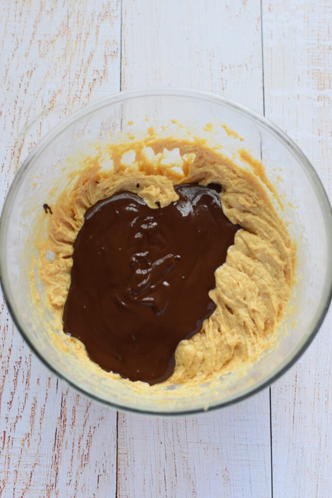 Adding melted chocolate to muffin batter.