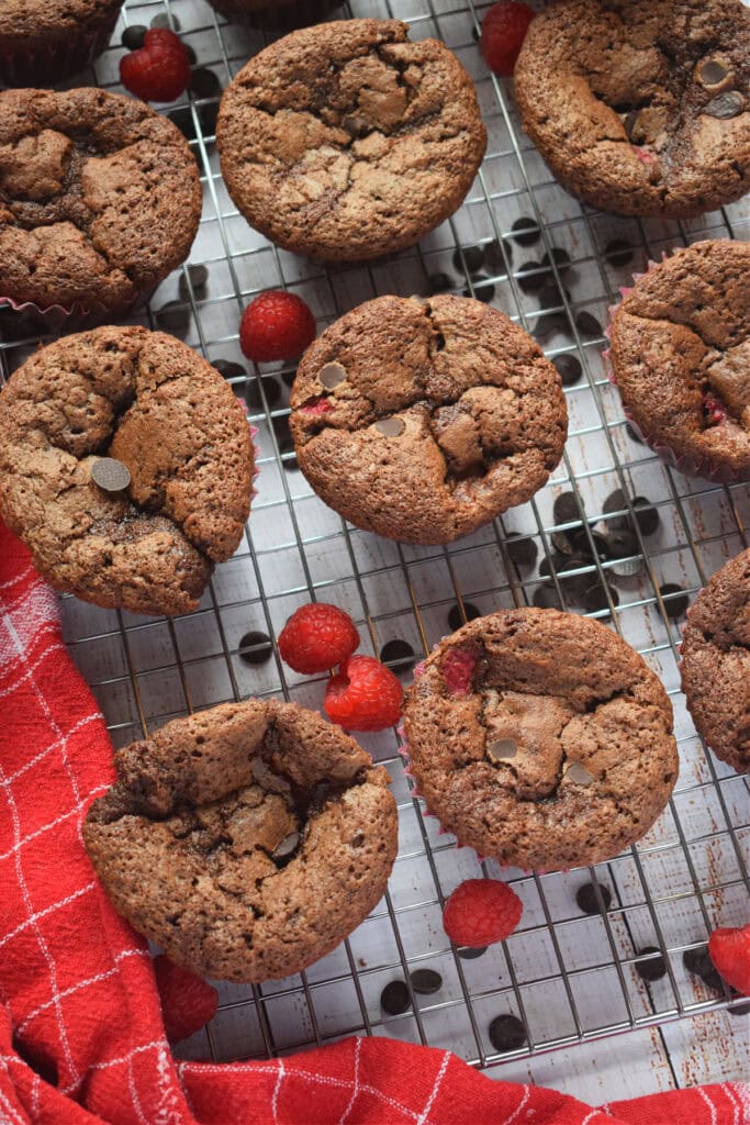 Chocolate raspberry muffins on a cooling rack.