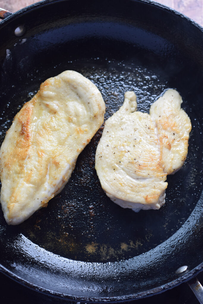 Cooking chicken in a skillet.