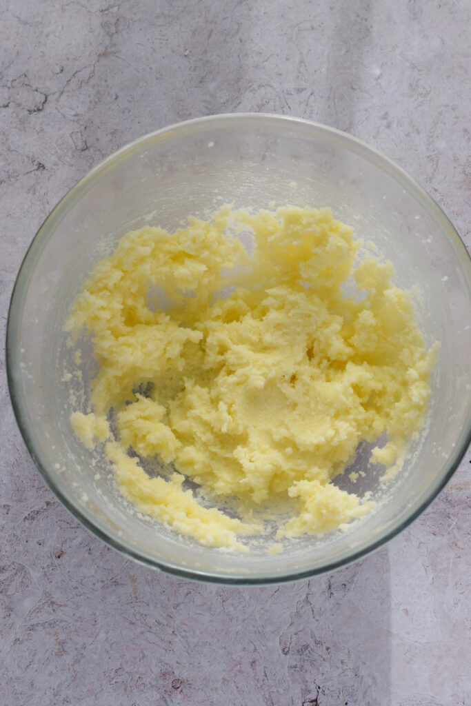 Mixed butter and sugar in a glass bowl.