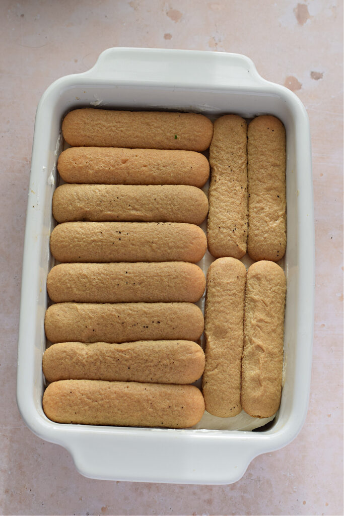 Making tiramisu in a baking dish.