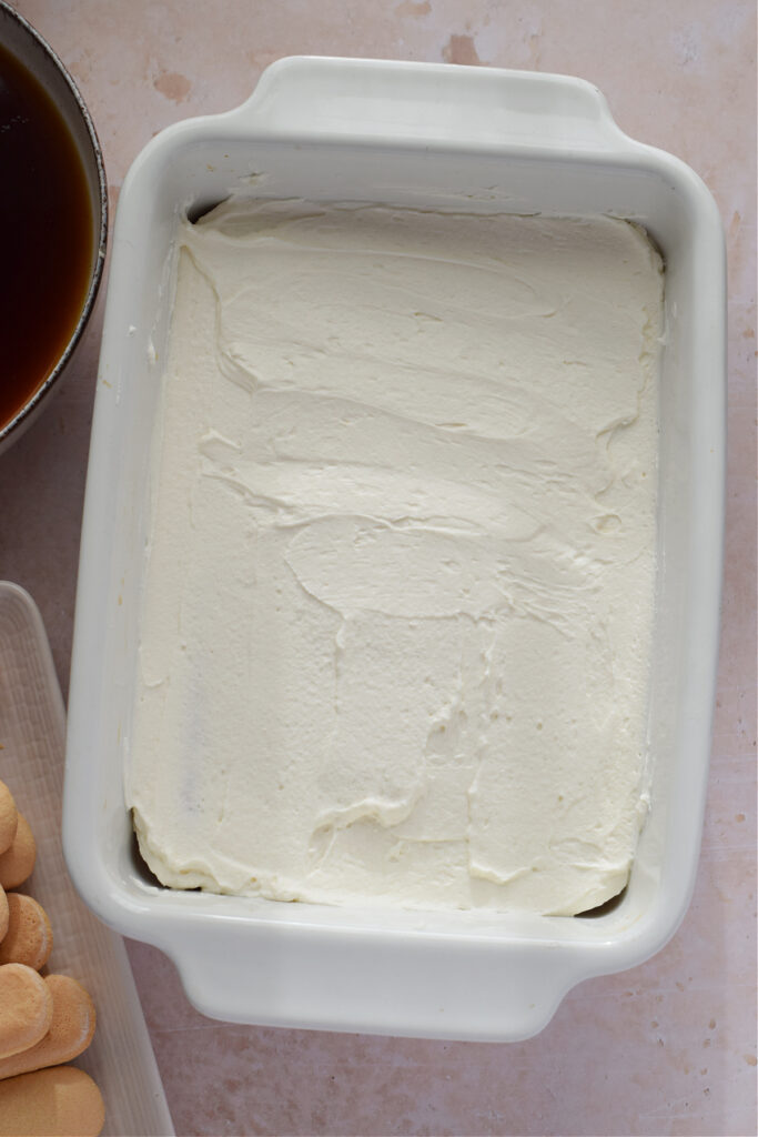 Making tiramisu in a baking dish.
