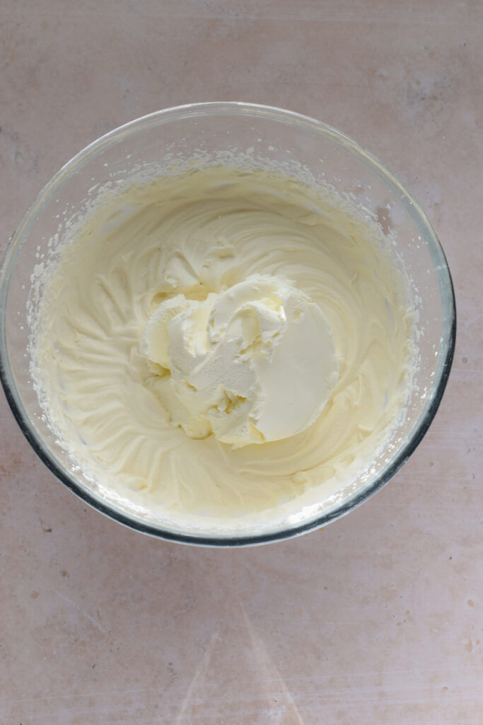 Add mascarpone cheese to whipping cream.