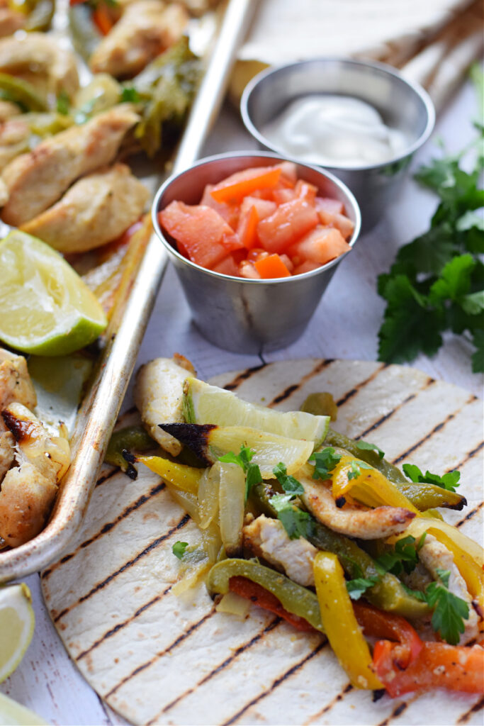 Close up of sheet pan chicken and peppers on a wrap.