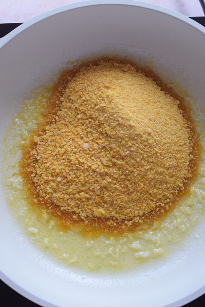 Adding bread crumbs to a skillet.