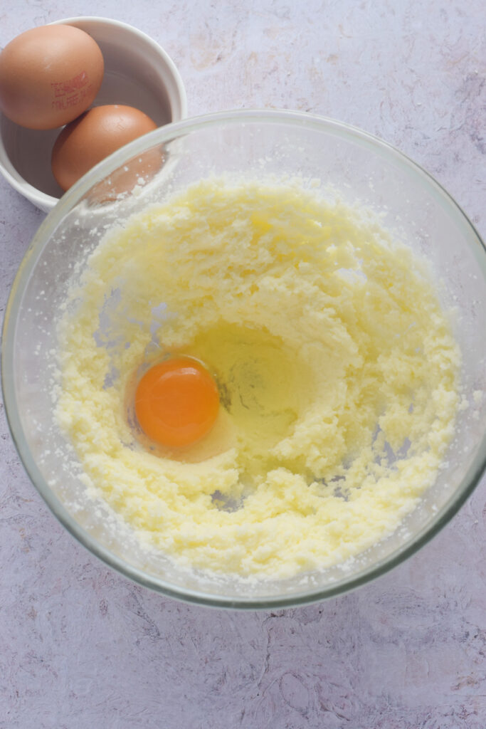Adding eggs to muffin batter.