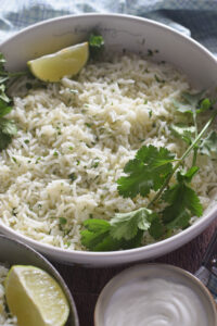 Close up of lime and cilantro rice in a white bowl.
