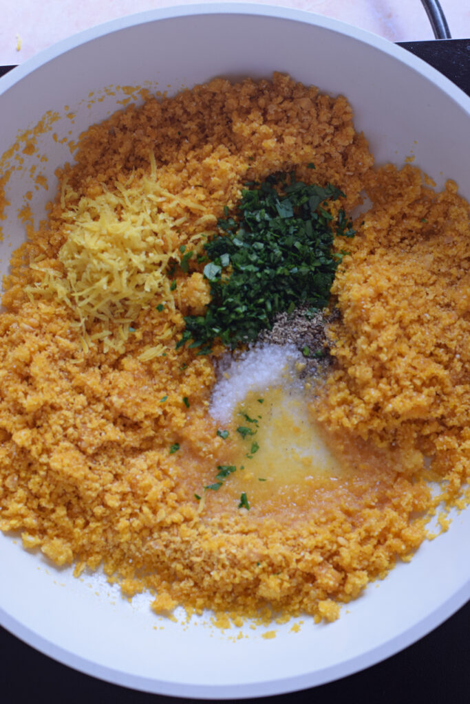 Adding seasonings to panko bread crumbs.