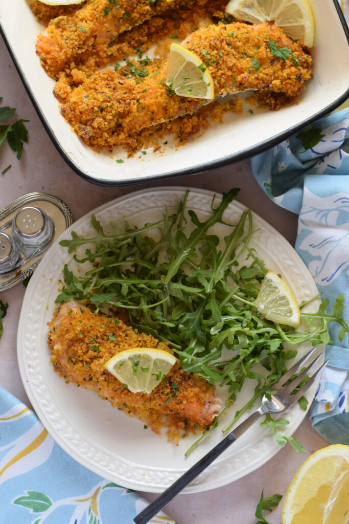 Panko crusted salmon on a plate with arugula.
