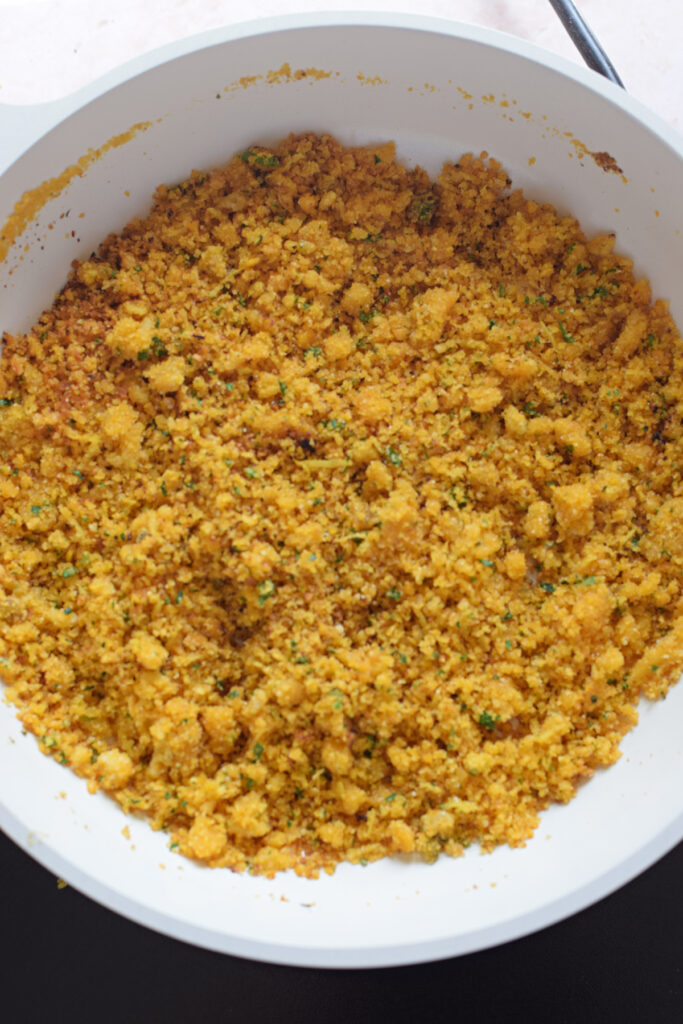 Seasoned bread crumbs in a white skillet.