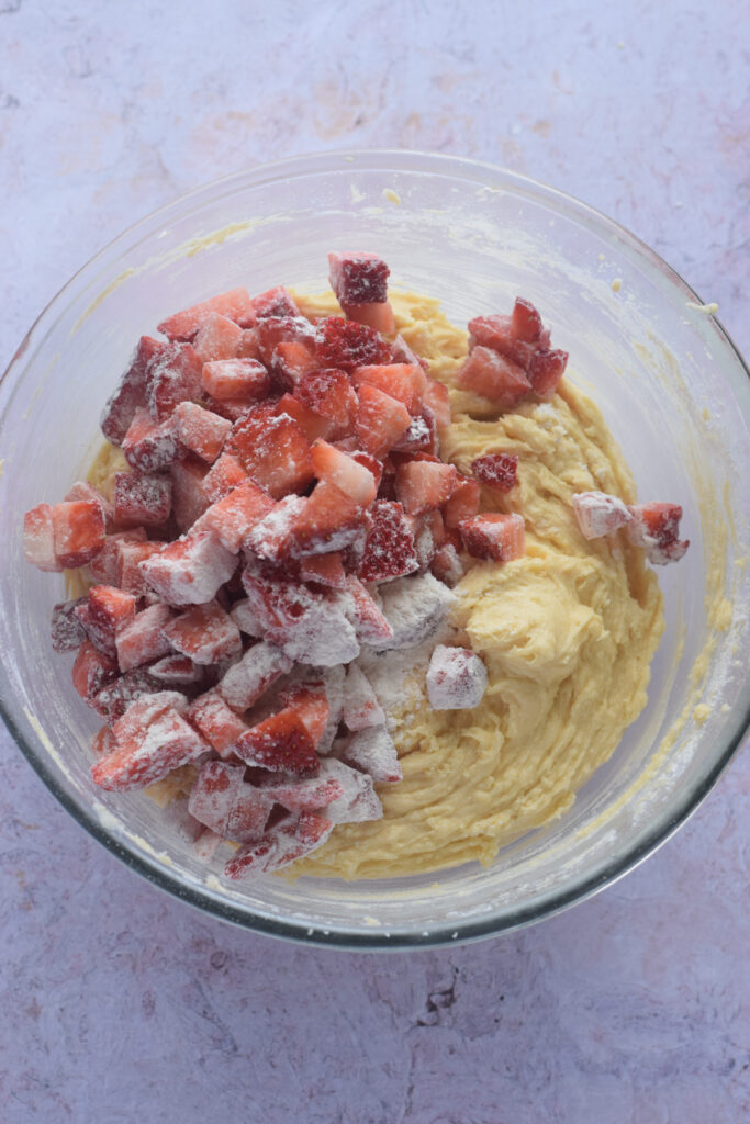 Adding strawberries to muffin batter.