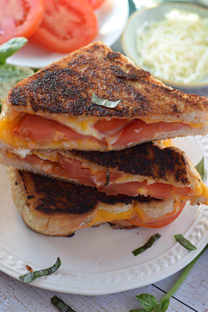 A stack of grilled cheese on a white plate.