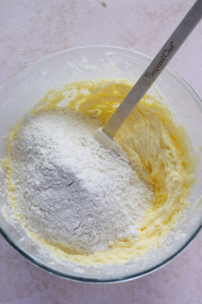 Adding flour to cake batter.