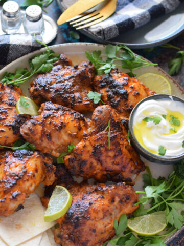 Close up of baked chicken on a plate with lemon.