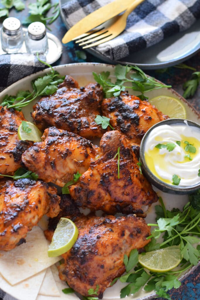Close up of baked chicken on a plate with lemon.