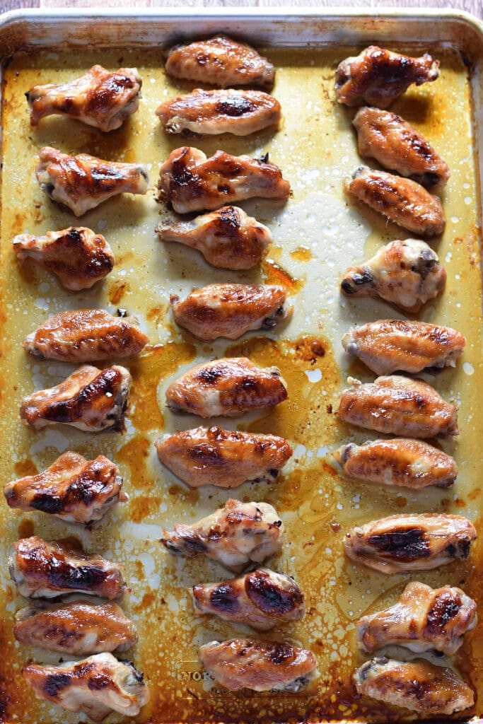 Baked teriyaki chicken wings on a baking tray.
