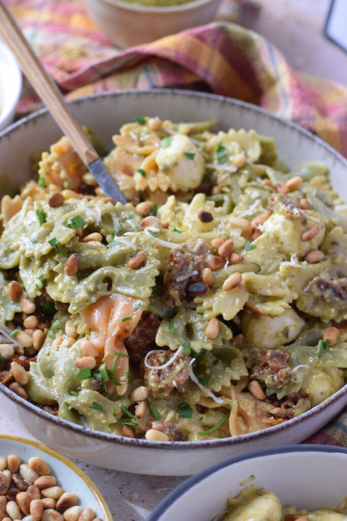 Close up of a green pesto pasta salad with bowtie pasta.