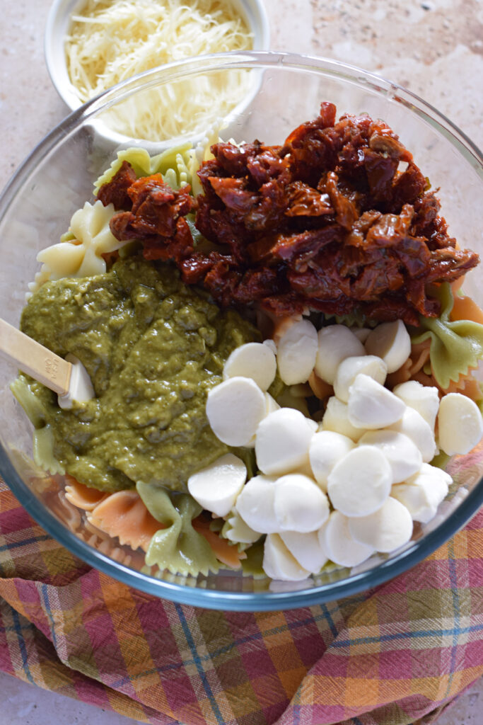 Making a pasta salad in a glass bowl.