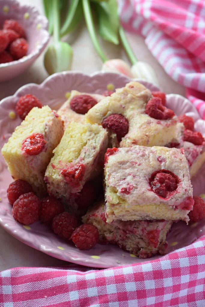 Raspberry cake squares on a plate.