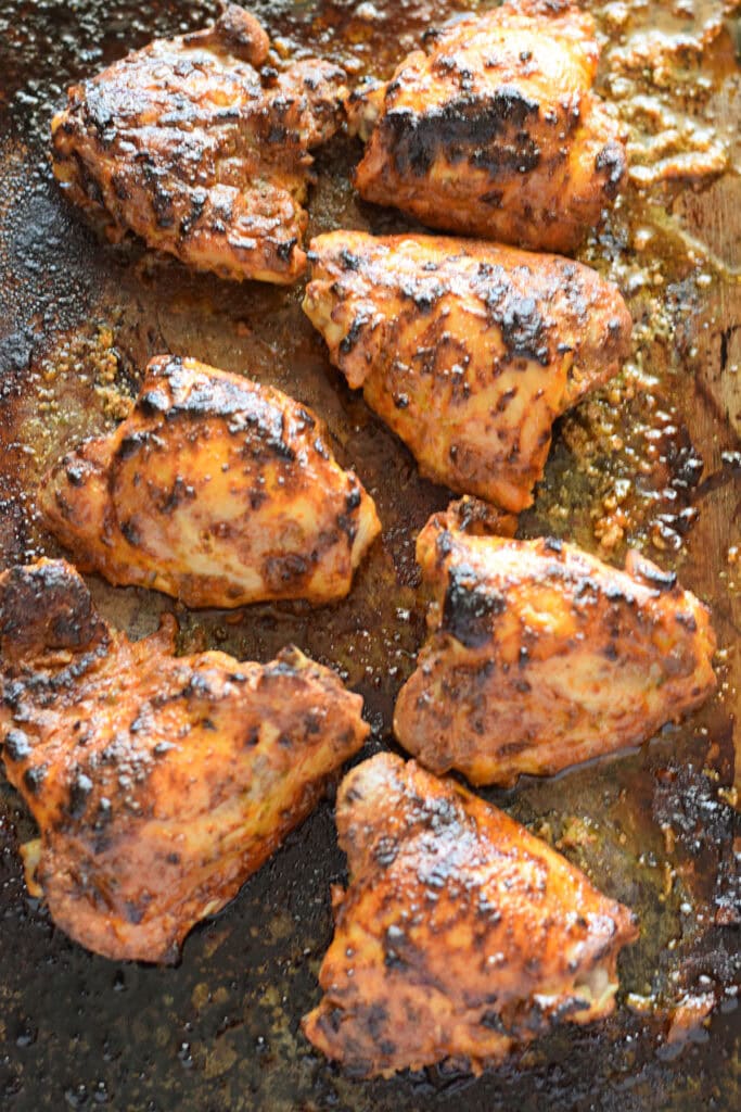 Baked chicken thighs on a baking trays.
