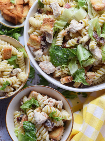 Pasta salad with chicken in a white bowl.