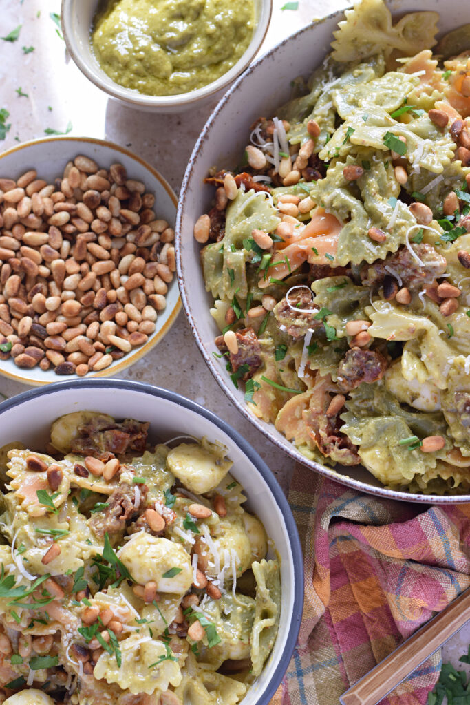 Close up of green pesto pasta salad in serving bowls.