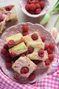 Raspberry cake squares on a pink plate.