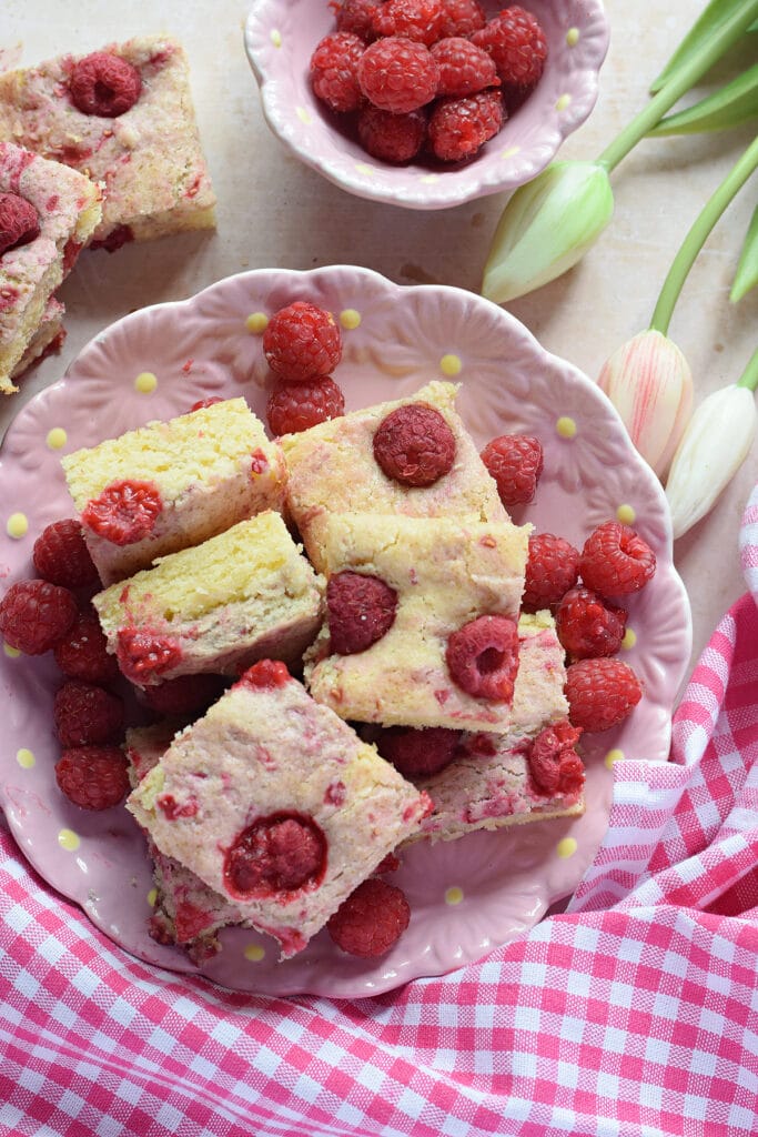 Raspberry cake squares on a plate.
