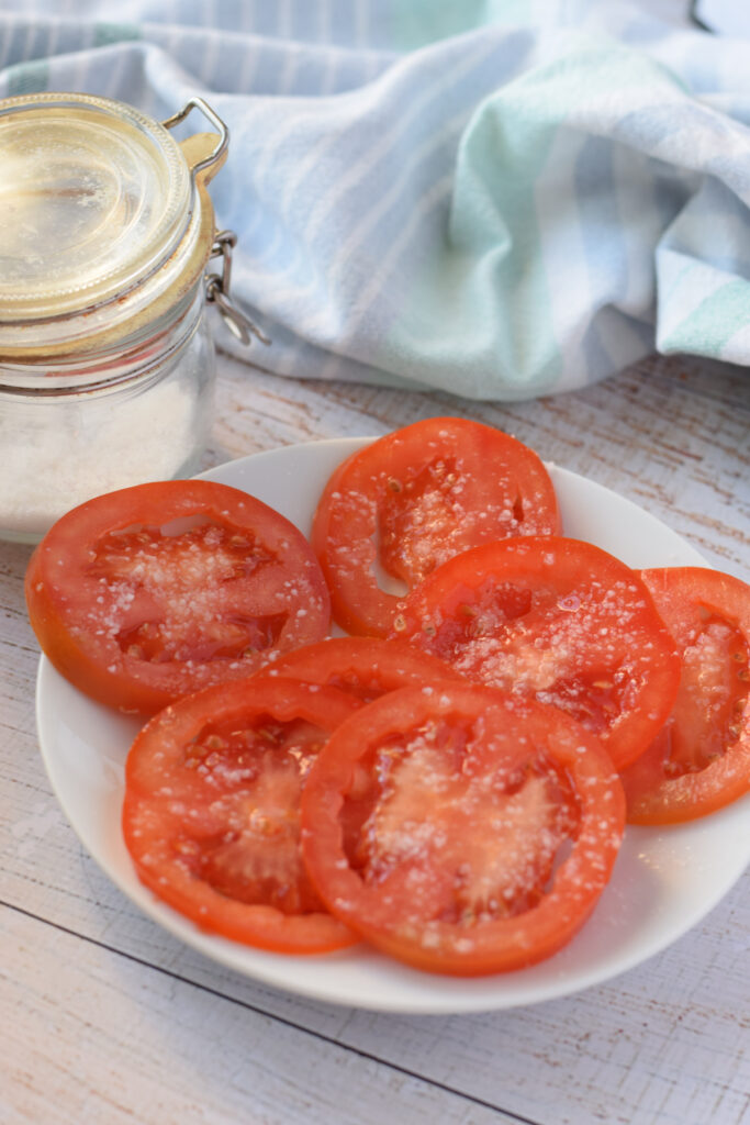 Sliced tomato on a white plate.