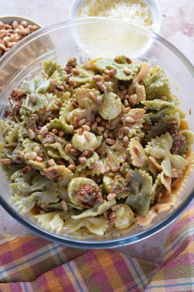Pesto pasta salad in a glass bowl.