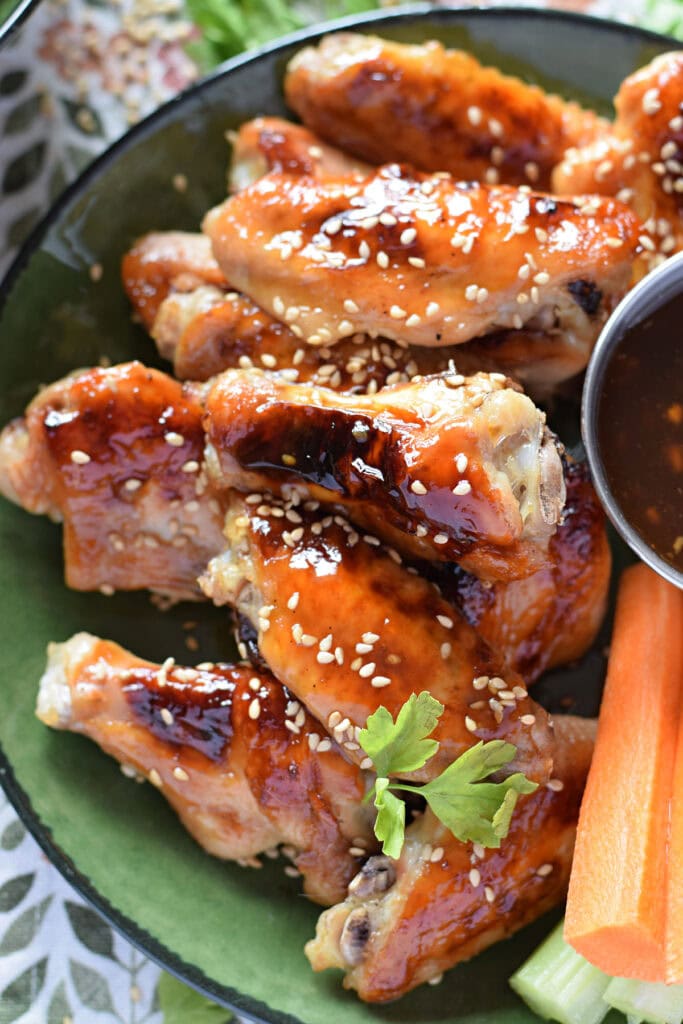 Close up of teriyaki chicken wings in a bowl.