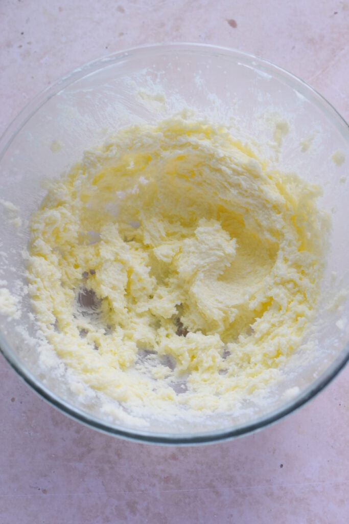 Mixed butter and sugar in a glass bowl.