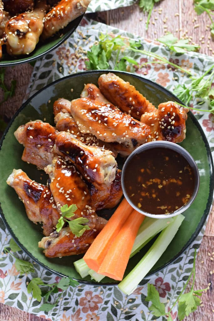 Baked teriyaki chicken wings in a green bowl.