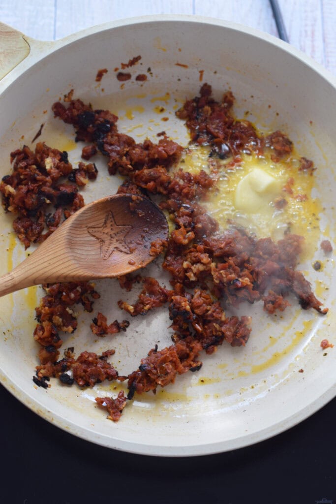 Add butter to a skillet with sun dried tomatoes.