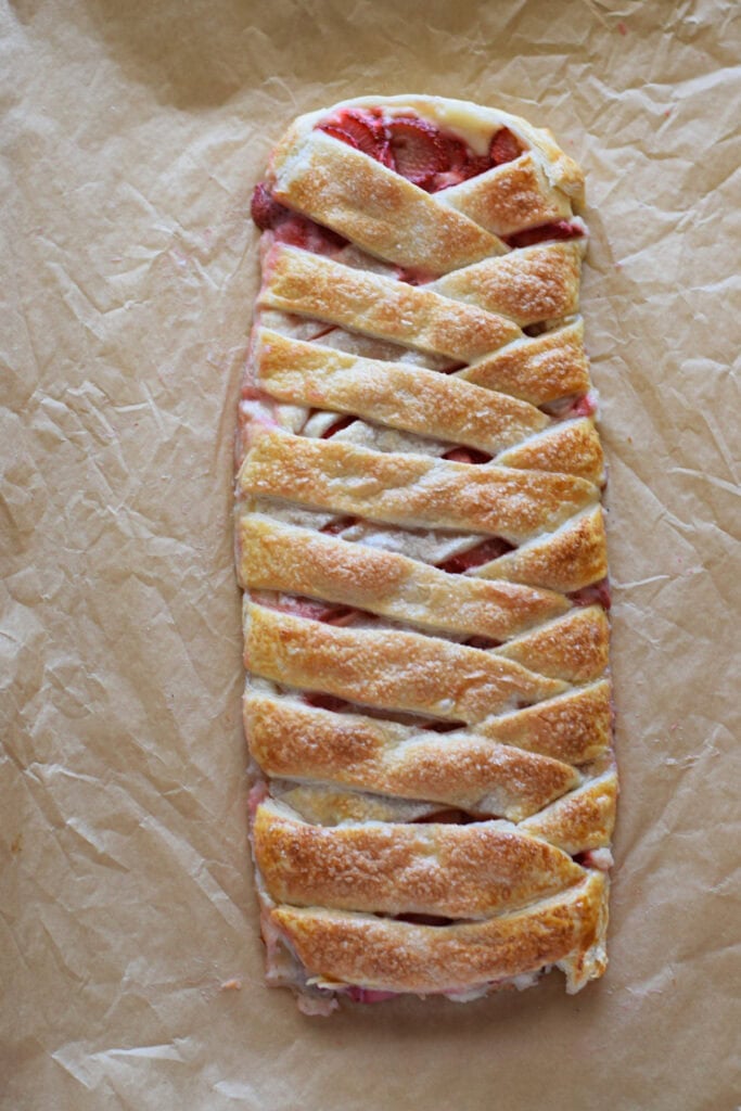 Baked strawberry cream cheese pastry braid on a baking tray.