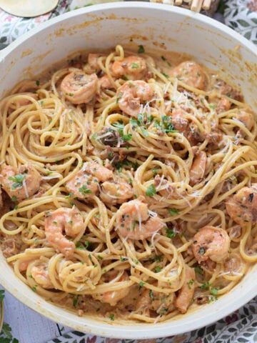Shrimp pasta in a white skillet.